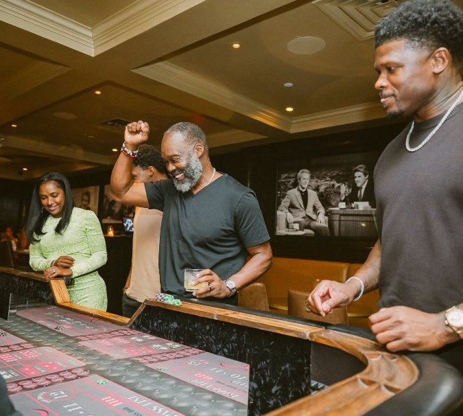 Members celebrating around a craps table on casino night